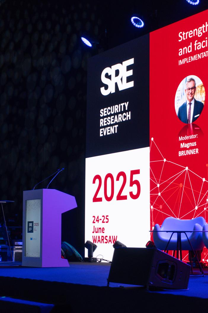 Zbliżenie na mównicę i ekran z datą i miejscem wydarzenia SRE 2025