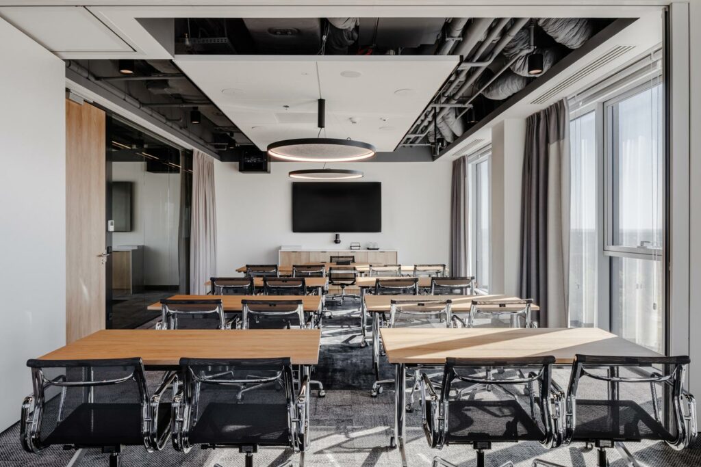 Sala szkoleniowa w biurze firmy doradczej w Warszawie z ekranem prezentacyjnym i systemem audiowizualnym Brill AV Media.