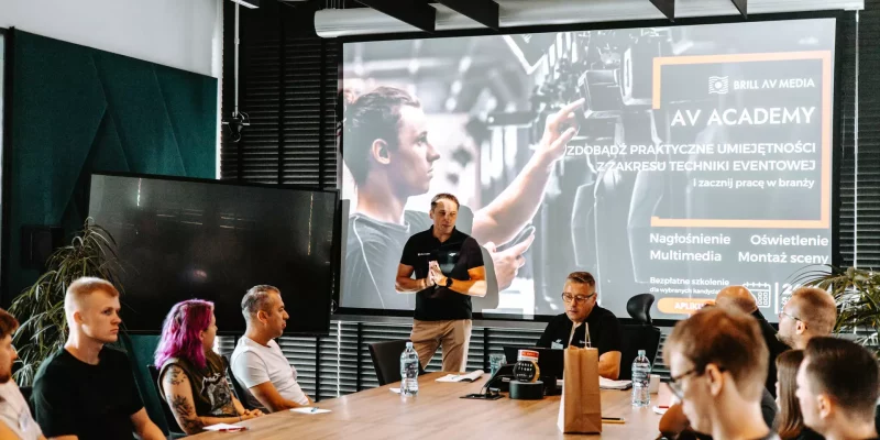 Prezentacja "AV Academy" o kursach techniki eventowej przed grupą uczestników.