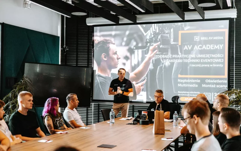 Prezentacja "AV Academy" o kursach techniki eventowej przed grupą uczestników.