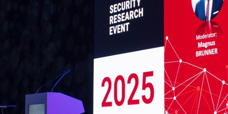 Zbliżenie na mównicę i ekran z datą i miejscem wydarzenia SRE 2025