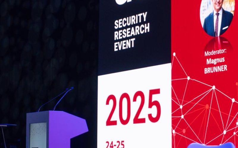 Zbliżenie na mównicę i ekran z datą i miejscem wydarzenia SRE 2025